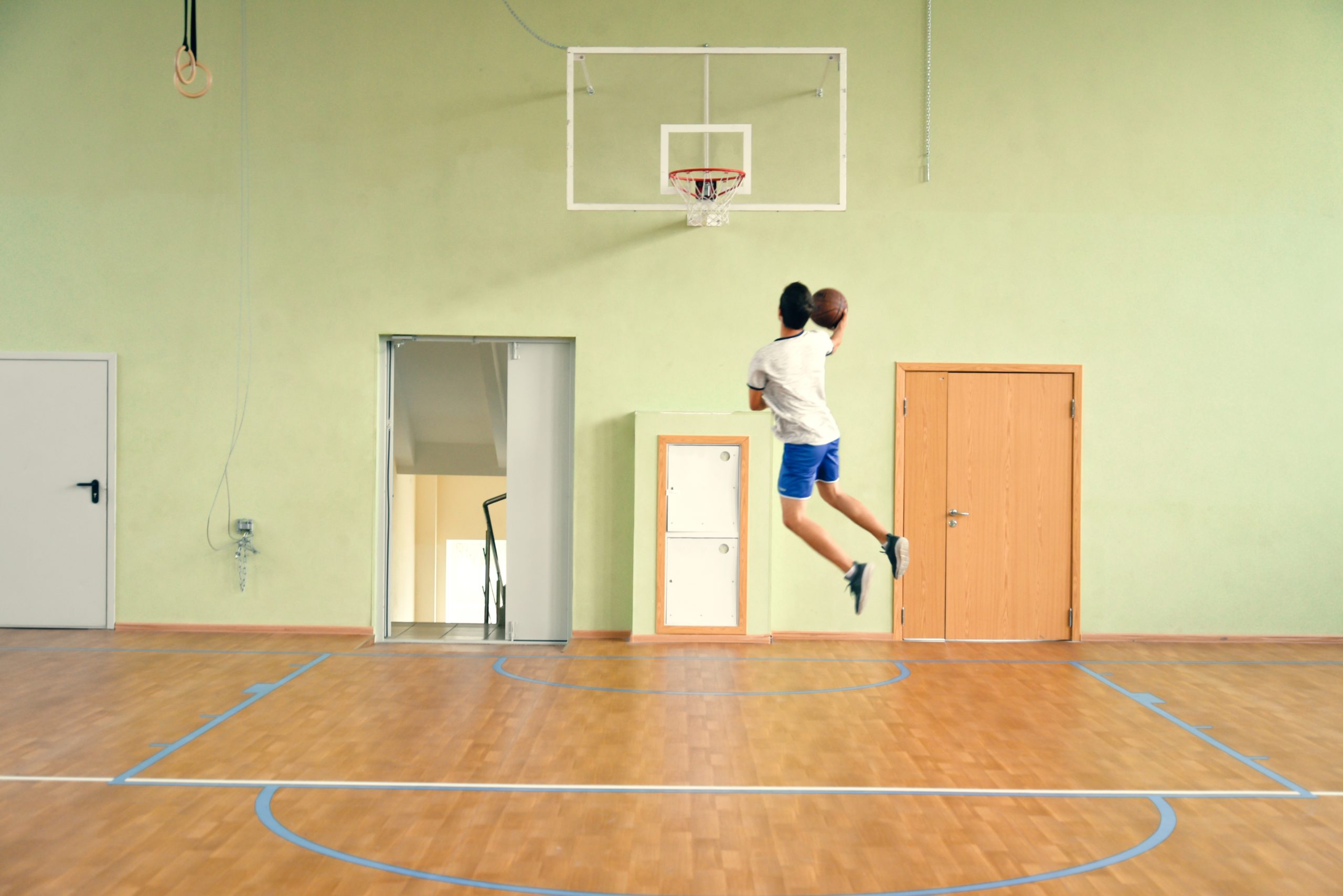 young-guy-in-the-gym-with-a-ball-playing-basketb-2022-11-15-16-23-54-utc